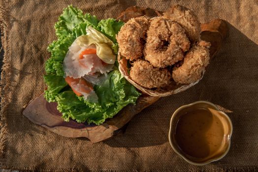 Deep-fried shrimp cakes (Tod Mun Goong) and vegetable with chili sauce on wooden background, Thai cuisine.