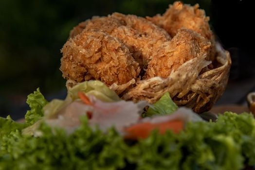 Close-up of Deep-fried shrimp cakes (Tod Mun Goong) and vegetable with chili sauce on wooden background, Thai cuisine.