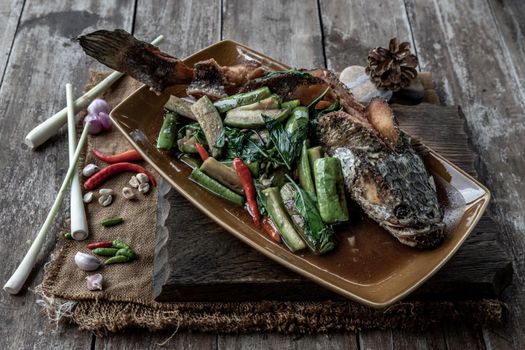 Deep fried whole Snakehead with Spicy stir fry eggplant, Thai food for health.