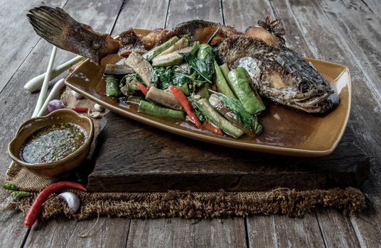 Deep fried whole Snakehead with Spicy stir fry eggplant, Thai food for health.