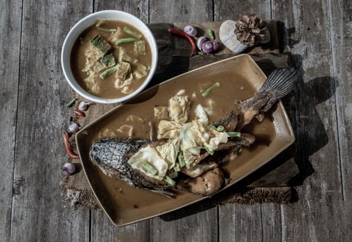 Deep fried whole Snakehad fish topped with Acacia omelets in vegetable sour soup (Orange curry with Cha-om).