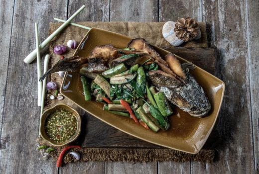 Deep fried whole Snakehead with Spicy stir fry eggplant, Thai food for health.