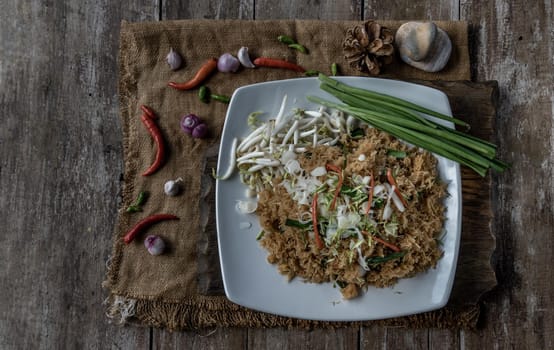 Asian eating food, Mee Grob is an sweet and sour crispy noodles, made from Thai rice noodle with sweet and sour sauce on white plate, Sweet & Sour Crispy Rice Noodles, Top view.