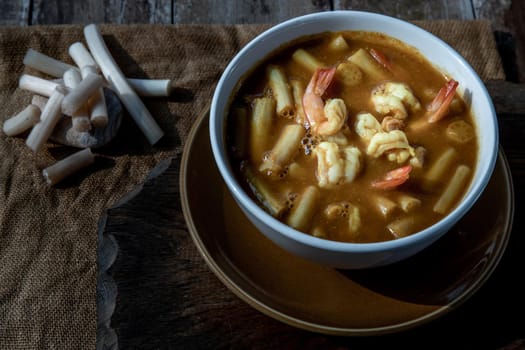 Sour soup with lotus stem and shrimps (kaeng som koong with lotus stem), Traditional Thai food, Oblique view from the top.