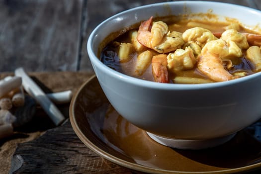 Sour soup with lotus stem and shrimps (kaeng som koong with lotus stem), Traditional Thai food, Oblique view from the top.