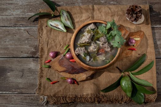 Pork spare rip Madan soup (Kra Dook Moo Tom Ma-Dun) in a Wooden bowl, Traditional Thai food, Top view.