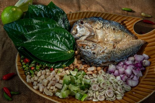 Thai Traditional Food : Fried mackerel served with fresh vegetable and herb, This food is thai food call Meuang Mackerel (Maing-Pla-too) menu.
