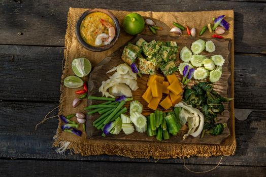 Thai Traditional Local Food : Shrimps chili dip or nam prik with shrimps (Nam Prik Goong Sod) with blanched vegetables and cha-om omelets on wooden backgroud.