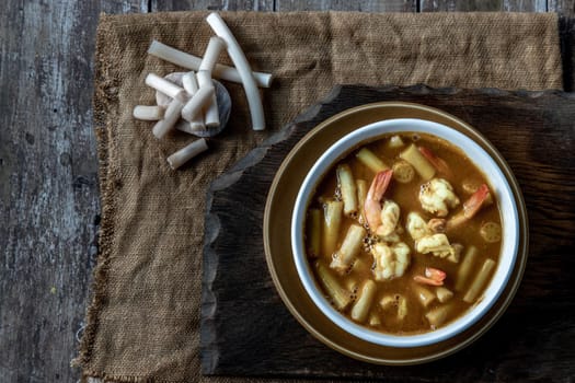 Sour soup with lotus stem and shrimps (kaeng som koong with lotus stem), Traditional Thai food, Top view.