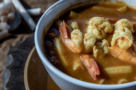 Close-up of Sour soup with lotus stem and shrimps (kaeng som koong with lotus stem), Traditional Thai food.