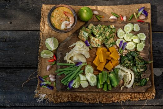 Thai Traditional Local Food : Shrimps chili dip or nam prik with shrimps (Nam Prik Goong Sod) with blanched vegetables and cha-om omelets on wooden backgroud.