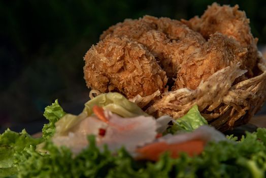 Close-up of Deep-fried shrimp cakes (Tod Mun Goong) and vegetable with chili sauce on wooden background, Thai cuisine.