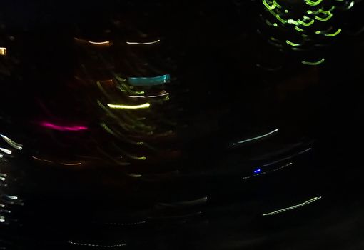 Reflection in a glass of glass. Blurred fires of distant houses. Window.