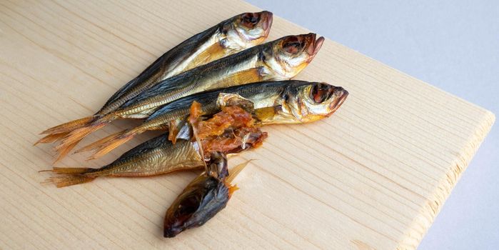 Horse mackerel fish, cold smoked. Smoked fish close-up on a wooden background .Food industry.
