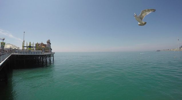 BRIGHTON, ENGLAND - 09 July, 2017: Panning shot of the pier and coastline on a hot summer day in Brighton