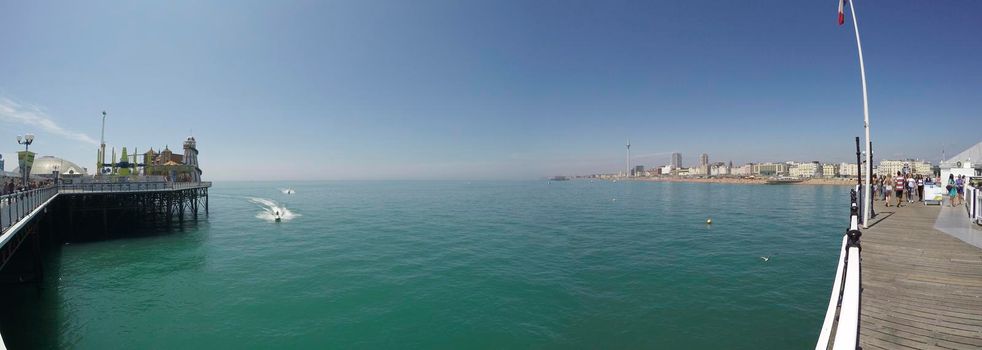 BRIGHTON, ENGLAND - 09 July, 2017: Panning shot of the pier and coastline on a hot summer day in Brighton