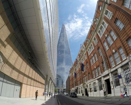 LONDON, ENGLAND- 29 June, 2017: Double decker bus passing in front of The Shard in London. The Shard is the tallest building in England.