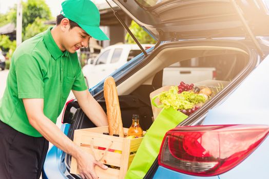 Asian delivery man grocery prepare service giving fresh vegetables food and fruit full in wooden basket on back car to send woman customer at door home after pandemic coronavirus, Back to new normal