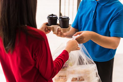 Asian young delivery man in blue uniform he making grocery service giving rice food boxes plastic bags to woman customer receiving front house under pandemic coronavirus, Back to new normal concept