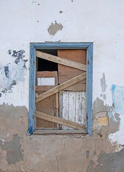 Old rustic wooden boarded up window in wall of abandoned traditional egyptian house