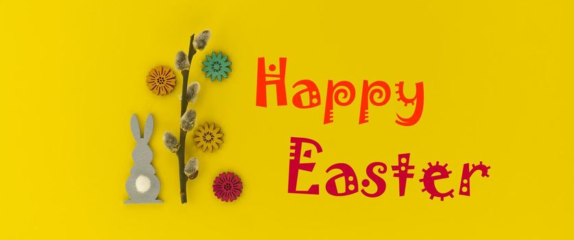 Banner. The minimal concept of Easter with Easter Bunny figure and pussy willow branch on yellow color background with text "Happy Easter"