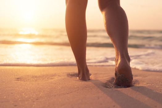 Woman feet walk slow life and relax on sand tropical beach with blue sky background.