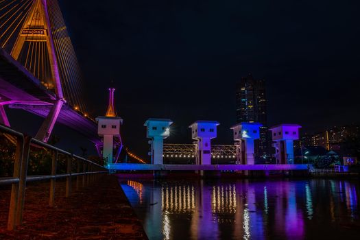 Samutprakan, thailand -  jun, 2019 : Bhumibol Bridge also casually call as Industrial Ring Road Bridge with floodgate illuminate with spotlight at night scene, Samut Prakarn, Thailand