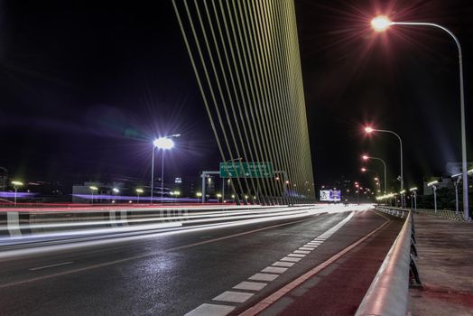 Bangkok, thailand - Nov 23, 2019 : Night sky at road on Rama VIII Bridge with car trails at twilight time in Bangkok, Thailand