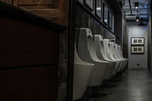 Bangkok, Thailand - Feb 14, 2020 : Public gentlemen toilet restroom. Contemporary interior of public toilet with men urinals. Interior and healthcare concept. Selective focus.