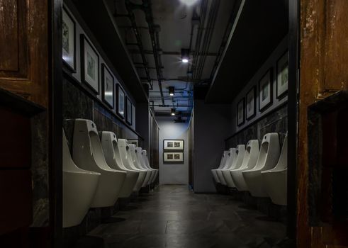 Bangkok, Thailand - Feb 14, 2020 : Public gentlemen toilet restroom. Contemporary interior of public toilet with men urinals. Interior and healthcare concept. Selective focus.