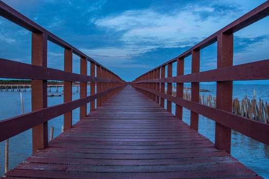 Beautiful of The walkway red wooden bridge in evening at Bang Khun Thian sea view, Bang Khun Thian, Bangkok, Thailand.