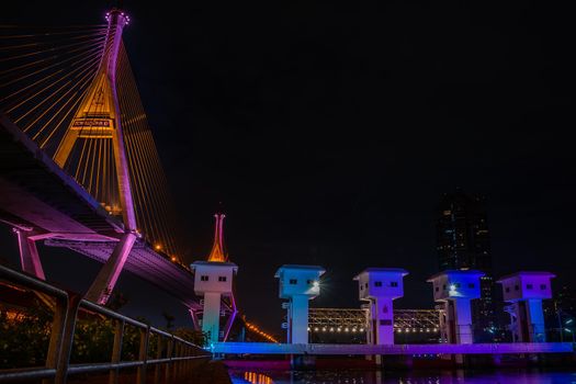 Samutprakan, thailand -  jun, 2019 : Bhumibol Bridge also casually call as Industrial Ring Road Bridge with floodgate illuminate with spotlight at night scene, Samut Prakarn, Thailand