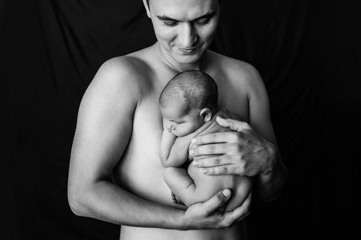 Father holding his newborn daughter at a newborn photoshoot. High quality photo