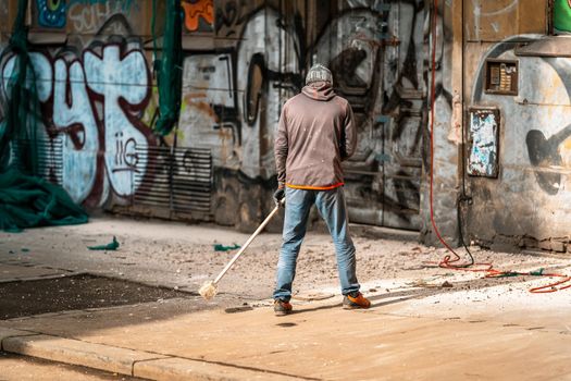 cleaning the city streets while repairing the facade of the house.