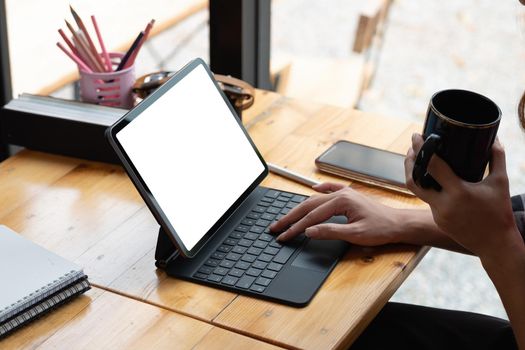 Close up hand of woman using blank screen digital tablet while working on his project