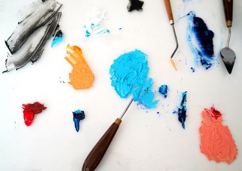 Detail of paint brushes and bright paint in an artist’s studio