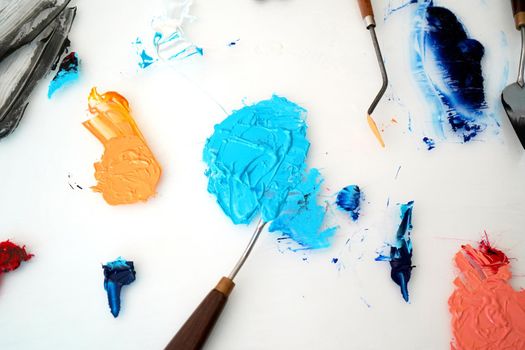 Detail of paint brushes and bright paint in an artist’s studio