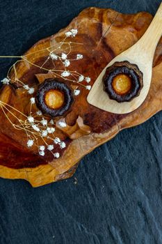Cannelés (Canelés) de Bordeaux Recipe is a small pastry with rum and vanilla on a wooden plate. Traditional French sweet dessert. tasty snacks. Top view. Place for text.