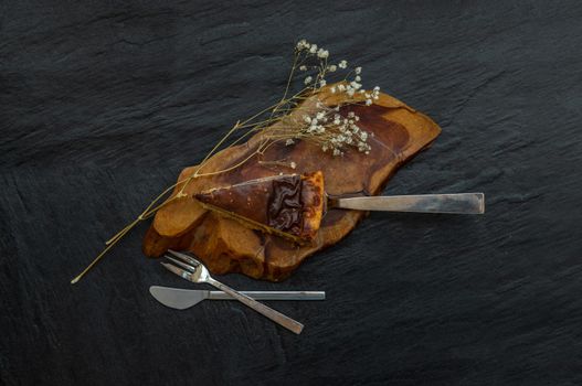 Slice of delicious fresh Tartellette creme brulee a la vanille on a wooden plate. Top view.