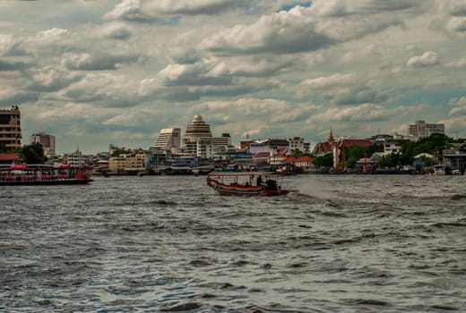 Bangkok, Thailand - 21 Jul 2019 : The passenger ferryboat on the Chao Phraya River showing the several other tall buildings in the background.