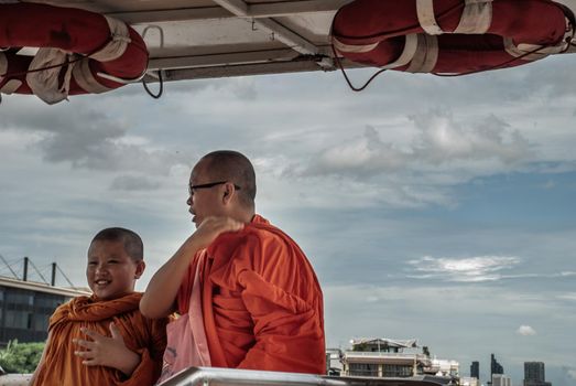 Bangkok, thailand 21 Jul, 2019 : The Monks and novices stood on the Chao Phraya Express Boat to travel by water to the temple.