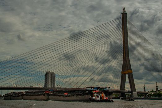 Bangkok, thailand 21 Jul, 2019 : Rama VIII bridge, Rope Bridge across the Chao Phraya River, A tall V-shape pylon tower with view blue sky is background, Cloudy day.