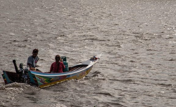 Bangkok, Thailand - 21 Jul 2019 : Long-tailed  boat rushing on water surface against of Chao Phraya to send passengers across the ferry.