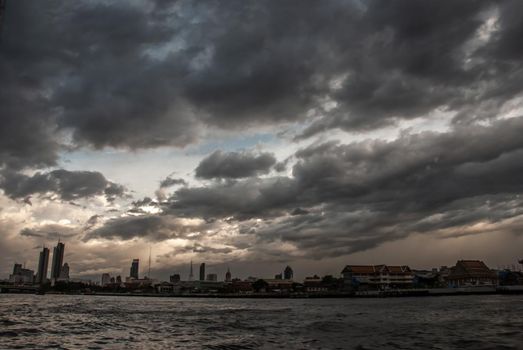Bangkok, Thailand - 21 Jul 2019 : A view of the bank of Bangkok's Chao Phraya River showing the several tall buildings in the beautiful evening sky.