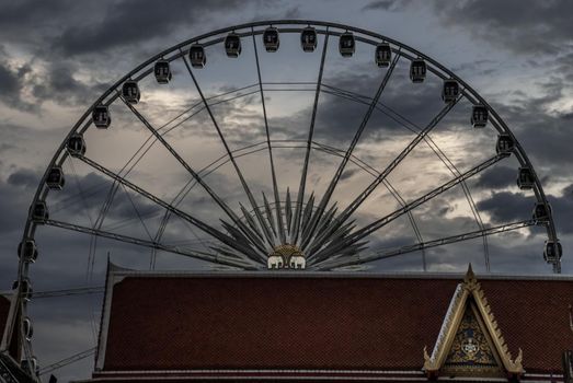 Bangkok, thailand 21 Jul, 2019 : The roof of the Wat Ratcha Singkhon with Asiatique Ferris Wheel and Blue Sky at a backdrop.