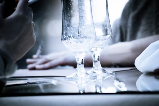 Hands holding a cigarette with empty beer glasses. Copy space