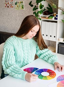 Artist or designer working with color wheel and color samples