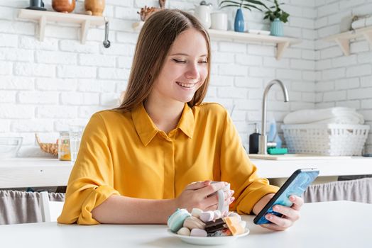 Attractive teenager woman in yellow shirt drinking tea