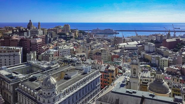 Aerial panoramic drone view of buildings and streets surrounding Port of Genoa.Important hub of maritime trade and tourist art.Old famous city of Italy,with beautiful architecture,houses,roofs.