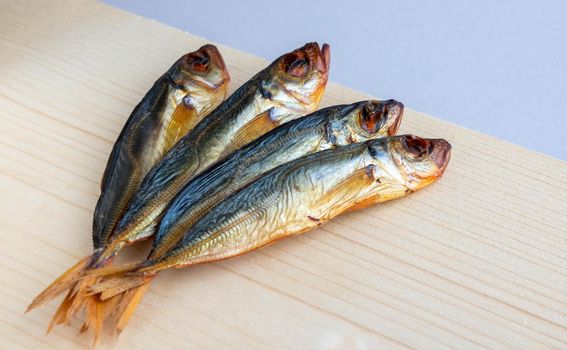 Horse mackerel fish, cold smoked. Smoked fish close-up on a wooden background .Food industry.